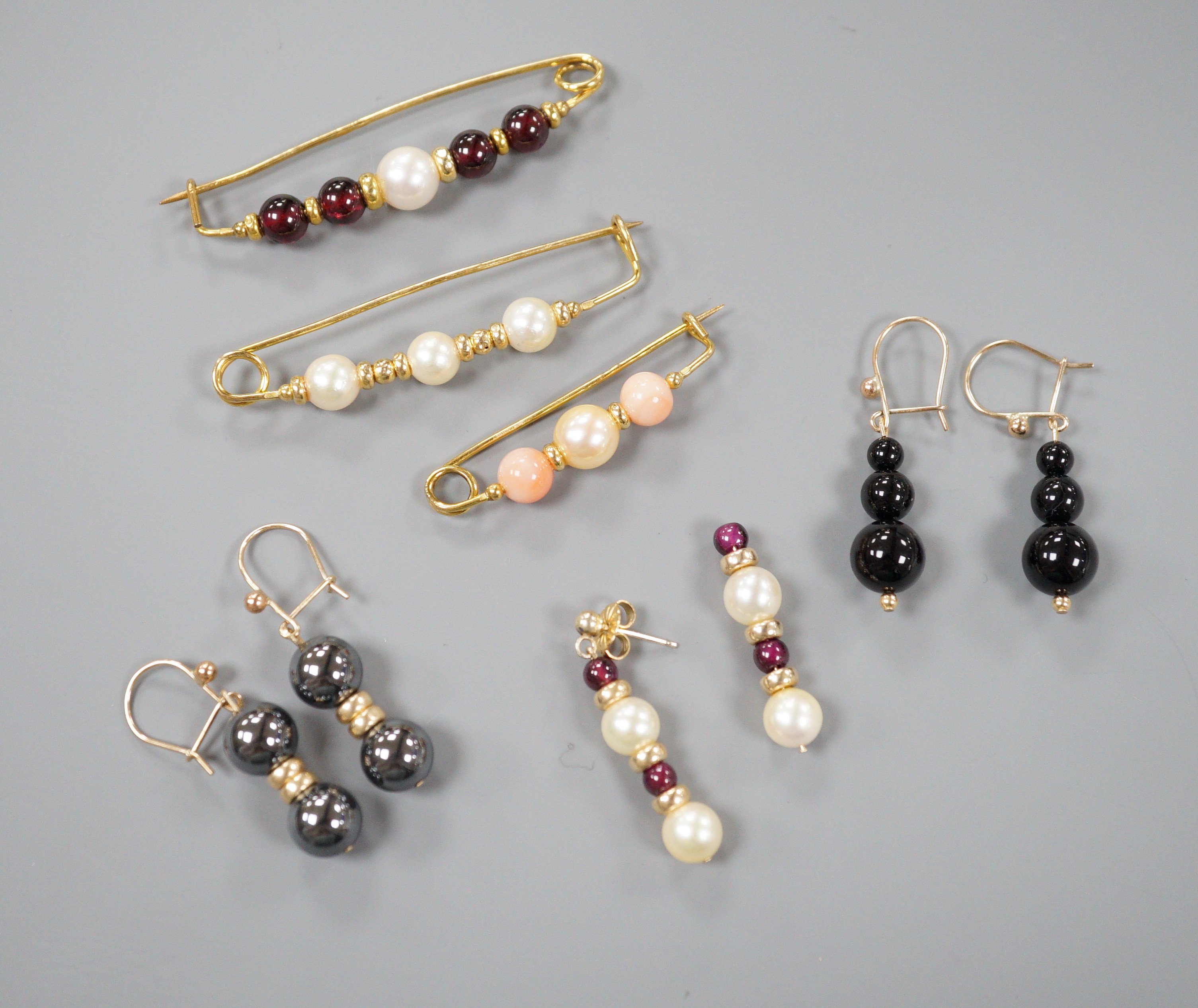 Three modern 9ct gold, cultured pearl and gem set brooches, largest 52mm and three modern pairs of yellow metal and gem set earrings, including hematite and 9k, gross weight 18.5 grams.